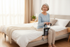 Elderly woman using product handrail to get up from bed